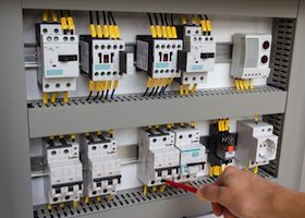 Technician Working At Electrical Cabinet