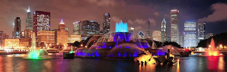 Chicago skyline panorama with skyscrapers and Buckingham fountain in Grant Park at night lit by colo